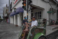 A man sits on his pedicab as he waits for passengers in the now-deserted tourist area of Jl Malioboro on April 5. JP/Arnold Simanjuntak
