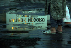 The reflection of Pathok Negoro Mosque’s signage in the puddle. JP/Boy T Harjanto