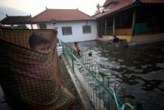 A boy waits for his friends by the pool. JP/Boy T Harjanto