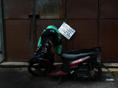 An ojek (motorcycle taxi) is parked in front of a closed shop in Green Ville housing complex in Tanjung Duren, West Jakarta. Many stores in the area have closed indefinitely following the coronavirus outbreak in the capital. JP/Sutrisno Jambul