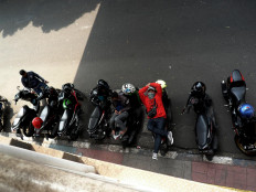 An ojek driver lies on his motorcycle near Palmerah railway station in West Jakarta. The decreasing number of customers has escalated the tension between conventional and online ojek drivers in the area. JP/Sutrisno Jambul