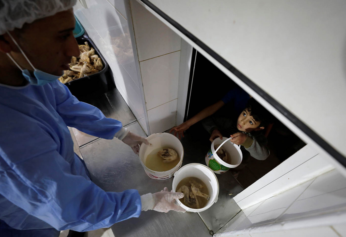 A Palestinian boy receives free Iftar (breaking fast) meals at a charity kitchen known as 'Prophet Ibrahim's Takiyya' during the holy month of Ramadan, amid concerns about the spread of the coronavirus disease (COVID-19) in Hebron, in the Israeli-occupied West Bank May 5, 2020. 