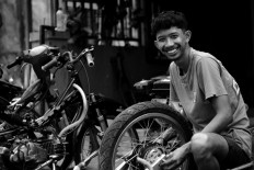 Imam installs parts of a wheel at his workshop in Bali.  JP/M Azis Dicky