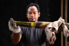 Marno, Sukri’s son-in-law, pulls out a freshly cooked lemang from the bamboo tube. JP/P.J.Leo
