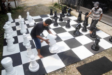 Two men play giant chess in front of a house in Pondok Betung in South Tangerang, Banten, on May 15 while waiting to break the fast. JP/Wendra Ajistyatama