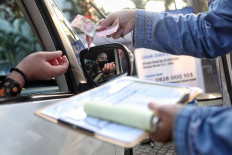A man pays alms at a drive-thru center at Nurul Hidayah Mosque in Jakarta on May 14. Muslims, if capable, need to pay alms ahead of Idul Fitri. JP/Seto Wardhana.

