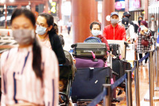 Keeping distance: Passengers maintain a safe distance while in line for their health and immigration check on Thursday at Soekarno-Hatta International Airport in Tangerang, Banten. Reuters/Ajeng Dinar Ulfiana
