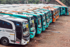 Going nowhere: Idle Gapuraning Rahayu buses are parked in a row on Wednesday in Pamalayan village, Ciamis, West Java. Several bus companies have temporarily suspended their interregional and intercity services in compliance with the government’s travel ban on mudik (exodus) to prevent the spread of COVID-19. Antara/Adeng Bustomi
