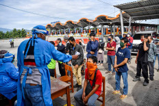 Medical screening: Medics check on the temperature of passengers and drivers who pass the Cipali Palimanan toll gate in Cirebon, West Java on Wednesday. Antara/Nova Wahyudi