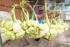 Business as usual: A ketupat package vendor puts his products on display in Depok, West Java, on Thursday. The ketupat is a popular dish during Idul Fitri in Indonesia. Antara/Asprilla Dwi Adha
