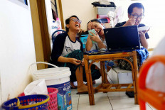New normal: Residents of a rooming house in Jakarta take part in a video call with their family members after Idul Fitri prayers on Sunday, in line with large-scale social restriction (PSBB) measures that require them to avoid large crowds. Reuters/Ajeng Dinar Ulfiana