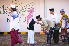 Giving thanks: A young man shows his respect to an older community member during an Idul Fitri celebration at the Jami’ Al-Makmur mosque in Leuwinanggung, Depok, West Java, on Sunday. JP/P.J.
Leo)