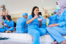 Selflessness: Medical workers who treat COVID-19 patients in Tangerang, Banten, enjoy a special Idul Fitri lunch break on Sunday. AFP/Fajrin Raharjo