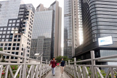 A man crosses a bridge at the Sudirman business area in Central Jakarta on May 20. The government expects that the gradual reopening of economic activities under the “new normal” protocols will start in the early of June. JP/Dhoni Setiawan