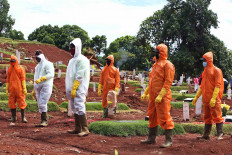Gravediggers and cemetery workers are readying to take part in the photo session of a stay at home campaign at the Pondok Ranggon public cemetery in East Jakarta on May 21. Indonesia recorded 1,496 COVID-19 deaths as of May 28. JP/P.J.Leo