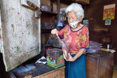 Gauw Cun Lan, a member of the Benteng Chinese community, packs coffee at her store in Pasar Lama, Tangerang, on May 26. Many stores in Pasar Lama have yet to reopen due to health concerns over the virus pandemic. JP/P.J.Leo

