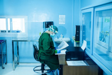 A laboratory worker writes down the code numbers of swab samples sent by Sanglah Hospital in Denpasar, Bali.  JP/Agung Parameswara