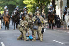 Military police officers are restraining a protestor near the White House on June 1, 2020 as demonstrations against George Floyd's death continue. - Police fired tear gas outside the White House late Sunday as anti-racism protestors again took to the streets to voice fury at police brutality, and major US cities were put under 
curfew to suppress rioting.With the Trump administration branding instigators of six nights of rioting as domestic terrorists, there were more confrontations between protestors and police and fresh outbreaks of looting. Local US leaders appealed to citizens to give constructive outlet to their rage over the death of an unarmed black man in Minneapolis, while night-time curfews were imposed in cities including Washington, Los Angeles and Houston. AFP/Roberto Schmidt