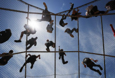 Protestors listen to speeches from atop a baseball backstop during a Black Lives Matter demonstration following the death of George Floyd on May 30, 2020 in Los Angeles, California. The vast majority of protestors demonstrated peacefully. Former Minneapolis police officer Derek Chauvin was taken into custody for Floyd's death. Chauvin has been accused of kneeling on Floyd's neck as he pleaded with him about not being able to breathe. Floyd was pronounced dead a short while later. Chauvin and 3 other officers, who were involved in the arrest, were fired from the police department after a video of the arrest was circulated. AFP/Getty Images/Mario Tama
