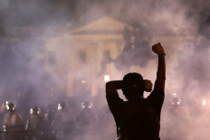 A man holds up his fist during a protest near the White House on May 31, 2020 in Washington, DC. Minneapolis police officer Derek Chauvin was arrested for Floyd's death and is accused of kneeling on Floyd's neck as he pleaded with him about not being able to breathe. Floyd was pronounced dead a short while later. Chauvin and three other officers, who were involved in the arrest. AFP/Getty Images/Alex Wong
