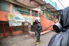 A member of the National Police Mobile Brigade&rsquo;s chemical, biological and radioactive hazards unit disinfects Cileungsi Market on Monday in Bogor regency, West Java. The market has been closed since May 31, when several traders were found to have contracted COVID-19. JP/P.J.Leo