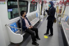 An LRT employee greets a passenger at Velodrome Station in Rawamangun, East Jakarta on June 9. The number of passengers per car is limited to 30. JP/Wendra Ajistyatama

