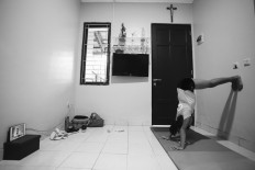 Ave performs a pike handstand. JP/Toto Santiko Budi