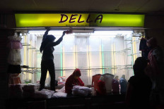 Traders prepare to open a clothing kiosk on June 15 at Tanah Abang Market in Central Jakarta. Market operator PD Pasar Jaya has applied the odd-even operating policy, with tenants permitted to open for business odd- or even-numbered dates to correspond with their kiosk’s lot number. JP/Dhoni Setiawan