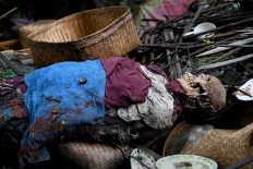 This picture taken on February 20, 2020 shows the body of a deceased at a cemetery where Bali's Trunyanese people hold open-air burials - before restrictions were implemented due to the COVID-19 coronavirus - near the village of Trunyan in Bangli Regency, near Lake Batur on Bali island. - For centuries Bali's Trunyanese people have left their dead to decompose in the open air, the bodies placed in bamboo cages until only the skeletons remain -- a ritual they haven't given up -- even as the COVID-19 pandemic upends burial practices worldwide.  AFP/Sonny Tumbelaka