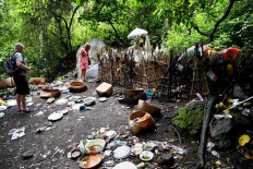 This picture taken on February 20, 2020 shows foreign tourists visit a cemetery where Bali's Trunyanese people hold open-air burials - before restrictions were implemented due to the COVID-19 coronavirus - near the village of Trunyan in Bangli Regency, near Lake Batur on Bali island. - For centuries Bali's Trunyanese people have left their dead to decompose in the open air, the bodies placed in bamboo cages until only the skeletons remain -- a ritual they haven't given up -- even as the COVID-19 pandemic upends burial practices worldwide.  AFP/Sonny Tumbelaka