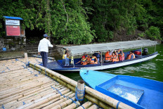 This picture taken on February 20, 2020 shows locals visiting a cemetery where Bali's Trunyanese people hold open-air burials - before restrictions were implemented due to the COVID-19 coronavirus - near the village of Trunyan in Bangli Regency, near Lake Batur on Bali island. - For centuries Bali's Trunyanese people have left their dead to decompose in the open air, the bodies placed in bamboo cages until only the skeletons remain -- a ritual they haven't given up -- even as the COVID-19 pandemic upends burial practices worldwide.  AFP/Sonny Tumbelaka