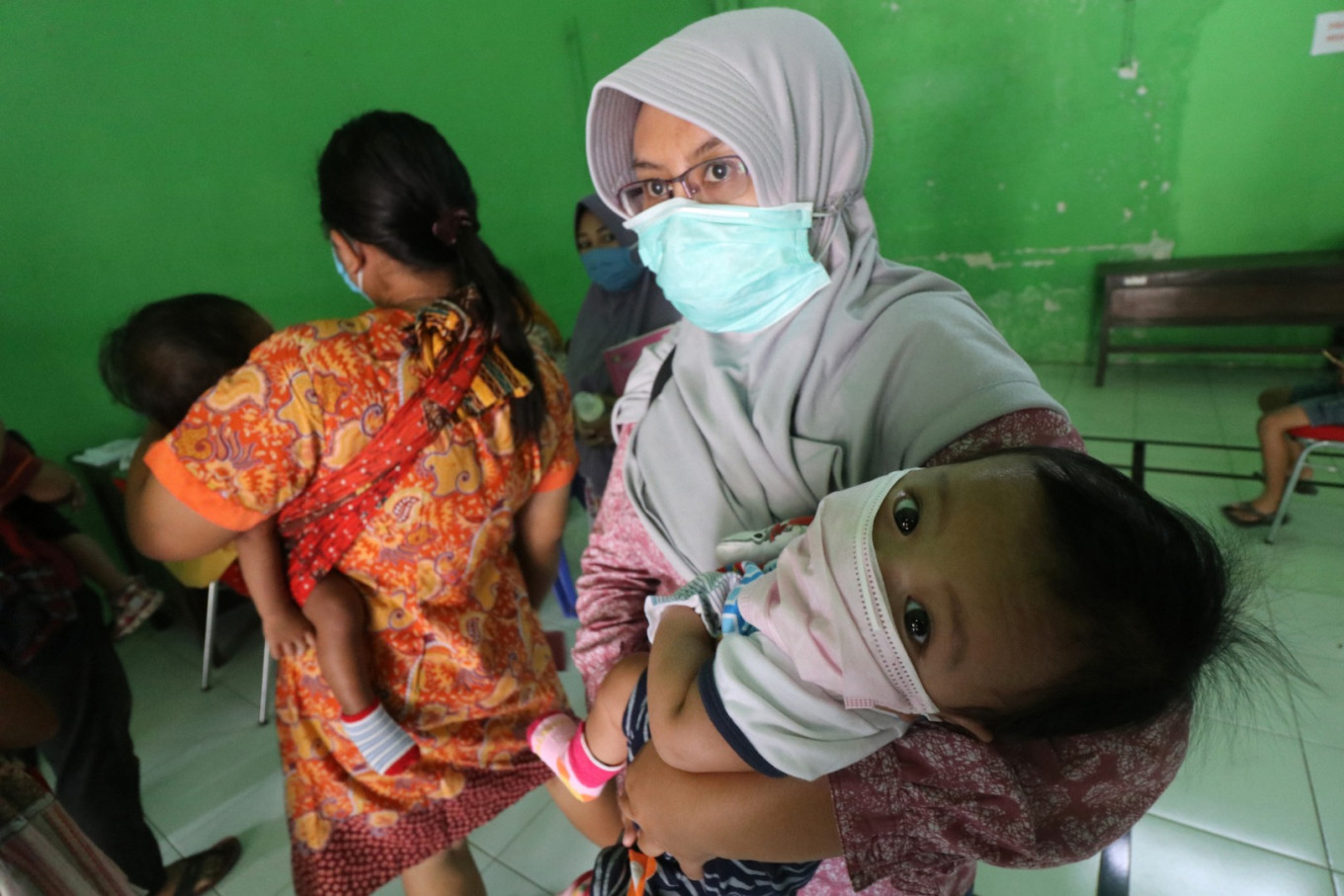 Safety first: Mothers stand in line to get their toddlers vaccinated at a village administration office in Kediri, East Java. The office is
being used for immunizations to prevent crowding at local community health centers (Puskesmas) and stem COVID-19 transmission.
