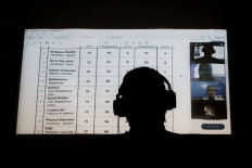 A teacher of Yasporbi elementary school in Jakarta speaks to his students and their parents through a video conference to discuss end-of-year report cards in Jakarta on June 26. JP/Seto Wardhana