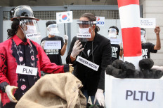 Activists from the Civil Society Coalition (Koalisi Masyarakat Sipil) stage a protest in front of the South Korean Embassy in Jakarta on June 30. The coalition opposed the construction of coal-fired power stations, known as the Java 9 and 10 PLTU, which they argued would damage the environment and people&rsquo;s health with their "dirty energy". JP/Seto Wardhana
