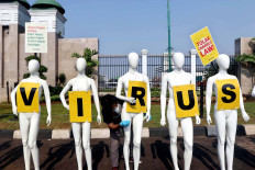 An environmentalist from Greenpeace Indonesia arranges mannequins as part of the NGO&rsquo;s protest in front of the House of Representatives&rsquo; complex in Central Jakarta on June 29. Greenpeace urged lawmakers to stop deliberating problematic bills and focus on curbing COVID-19 in the country. The mannequins represented the dozens of other environmentalists who could not attend the protest because of large-scale social restrictions. JP/Dhoni Setiawan