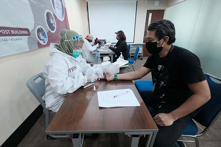 Get it done: An employee of "The Jakarta Post" has his finger pricked during a rapid test at the "Post"’s building in Palmerah, Central Jakarta, on Tuesday. The rapid testing was held in cooperation with
Antara national news agency as part of efforts to contain the spread of COVID-19.