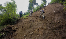 SMP 4 Bawang principal Mulud Sugito and teacher Wiyata Bhakti climb a hill to drop off weekly assignments in Batang regency, Central Java. Antara/Harviyan Perdana Putra