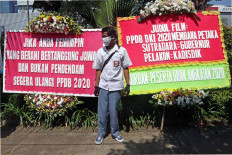 A senior high school student stands in front of flower boards at City Hall protesting alterations to the public school enrollment system in Central Jakarta on July 6. Many parents are unhappy with the enrollment system, which prioritizes age over performance. JP/Dhoni Setiawan