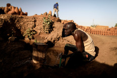 David Plantino, 35, a pottery maker from South Sudan, cools himself down with water from the Nile river, next to a workshop in an area known as the 'Potters Village' in Alqamayir, Omdurman, Sudan, February 16, 2020. Reuters/Zohra Bensemra