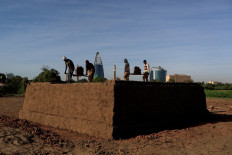 Mohamed Ahmed al Ameen (L), 55, and Mustapha (R), 60, who are both brick makers, prepare bricks to be fired in a kiln at an open-air factory on Tuti Island, Khartoum, Sudan, February 12, 2020. Reuters/Zohra Bensemra
