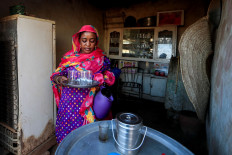 Ibtissam, 46, whose husband Mutasim al-Jeiry is a pottery maker, carries a tray out of the kitchen at their home in an area known as the 'Potters Village' in Alqamayir, Omdurman, Sudan, February 18, 2020. "Our life depends on the mud of the Nile, without it we will not eat", said Ibtissam. Reuters/Zohra Bensemra     
