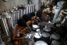 Workers make baking pans at a small business in Kampung Tonggoh, Bogor regency, on July 22. After halting production for several months due to the COVID-19 pandemic, many small and medium enterprises (SMEs) in the area – the majority of which specialize in producing baking pans – are slowly starting to reopen. JP/P.J.Leo