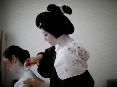 Koiku paints the back of Mayu's neck, both of whom are geisha, as they get ready at Ikuko's home to work at a party being hosted by customers at a restaurant, where they will be entertaining with other geisha, during the coronavirus disease (COVID-19) outbreak, in Tokyo, Japan, June 23, 2020. Reuters/Kim Kyung-Hoon 
