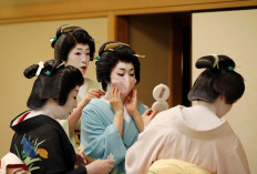 Senior geisha help Koiku put on a protective face mask to have a portrait photo taken of her wearing one for Reuters, before working at a party being hosted by customers, where she will entertain with other geisha, at Asada, a luxury Japanese restaurant, during the coronavirus disease (COVID-19) outbreak, in Tokyo, Japan, June 23, 2020. Reuters/Kim Kyung-Hoon 