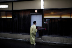 Koiku, who is a geisha, folds a traditional umbrella made out of oil paper, as she arrives at a restaurant where she will work at a party hosted by her customers, where she will entertain, during the coronavirus disease (COVID-19) outbreak, in Tokyo, Japan, July 13, 2020. Reuters/Kim Kyung-Hoon 