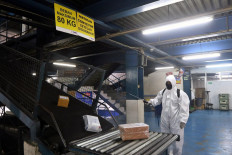 A worker disinfects the sorting area of courier company TIKI at Jl. Pemuda, East Jakarta, on July 28. Amid the pandemic, TIKI implements strict health protocols by conducting temperature checks on its workers and customers, providing hand sanitizer and disinfecting its stores and warehouses regularly. JP/Dhoni Setiawan
