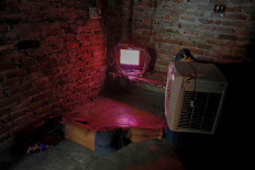 Latif Khan, 11, who's father Mansoor Khan works as a waste collector, watches a movie on television inside their home, which is next to a landfill site, during the coronavirus disease (COVID-19) outbreak, in New Delhi, India, July 15, 2020. Reuters/Adnan Abidi 