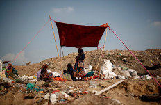 Latifa Bibi, 38, who is married to Mansoor Khan, a waste collector, shields herself from the sun, under a blanket with other waste collectors, at a landfill site during the coronavirus disease (COVID-19) outbreak, in New Delhi, India, July 9, 2020. Reuters/Adnan Abidi 
