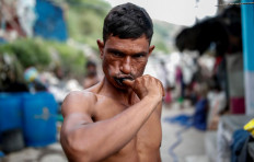 Mansoor Khan, 44, a waste collector, uses a piece of charcoal to clean his teeth, outside his home which is next to a landfill site, during the coronavirus disease (COVID-19) outbreak, in New Delhi, India, July 16, 2020. Reuters/Adnan Abidi