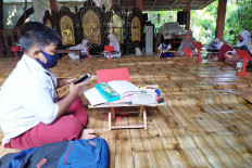 A student does schoolwork online at the home of Sri Wiwoho, a resident of the Depok Mulya I housing complex, in Depok, West Java, on Aug. 3. Sri has provided a learning space and free internet access for children in the neighborhood. JP/P.J. Leo